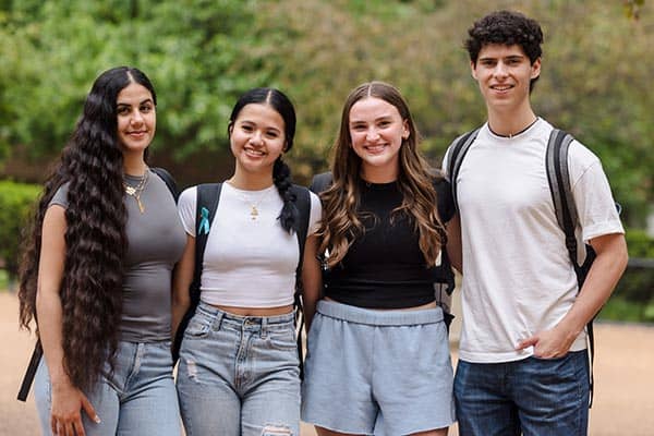 Four students pose for a photo on SLU's campus