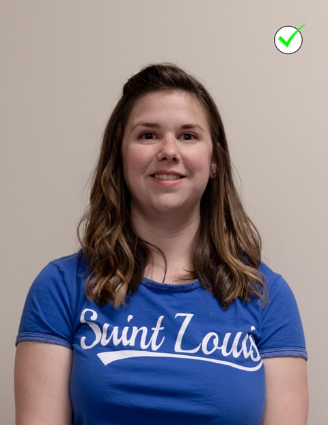 Good example of ID photo A headshot of a woman wearing a SLU t-shirt. The photo is well-lit and the woman is centered in the frame and is smiling naturally at the camera.