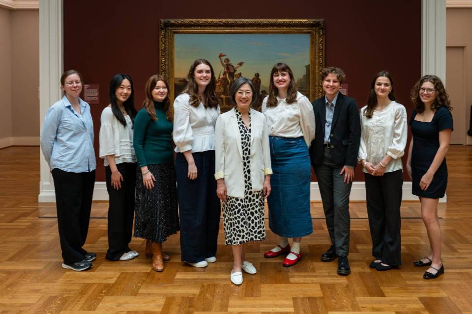 a group of people stand in an art museum a group of people stand in an art museum