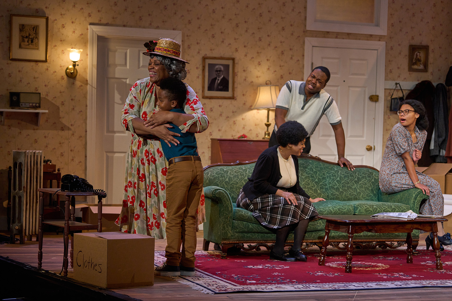 The Cast of 'A Raisin in the Sun' A Black family sits in the living room, with Grandma hugging her Grandson.
