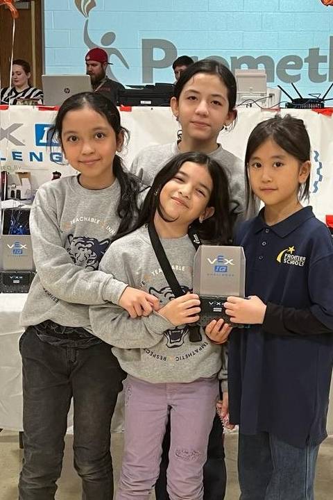 Four students pose with an awards plaque