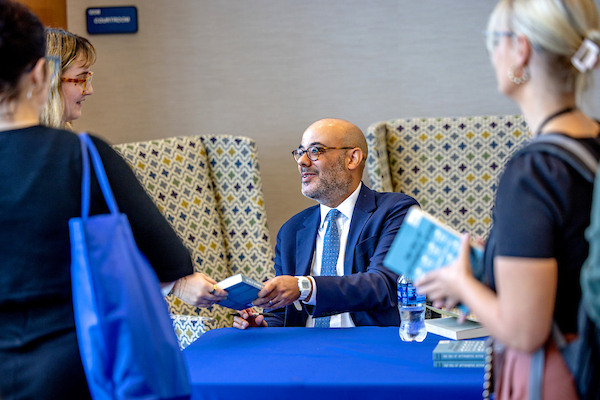 Professor Driver signs copies of his book for law students