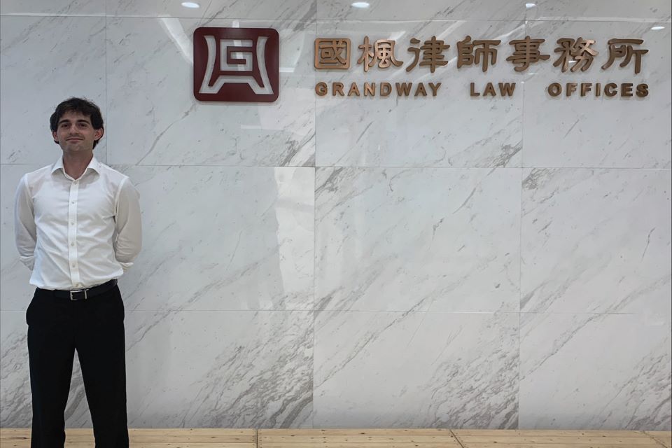 Justin Fuller poses outside of the law firm where he did his international internship