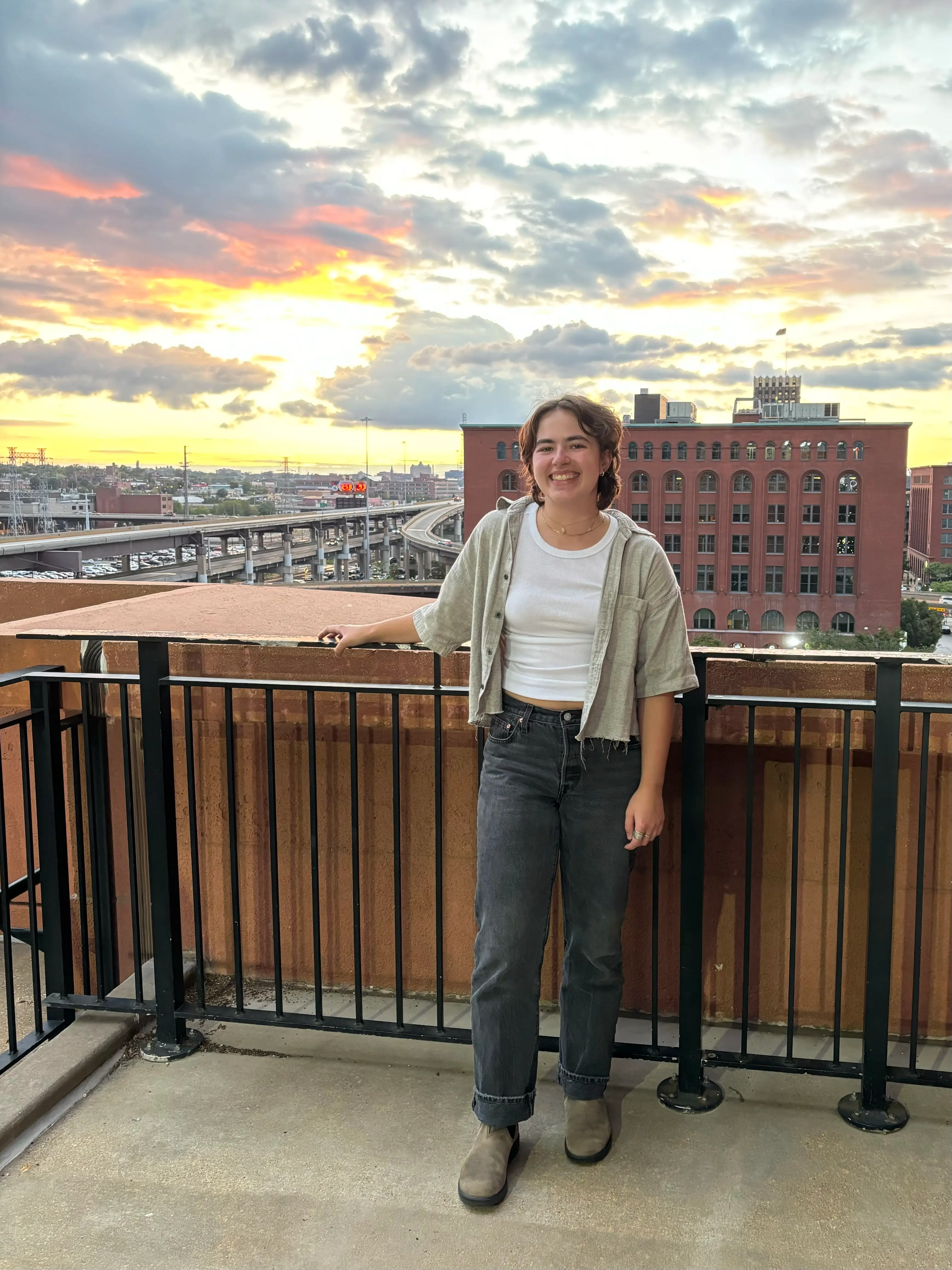 Rachel M. stands on a roof top