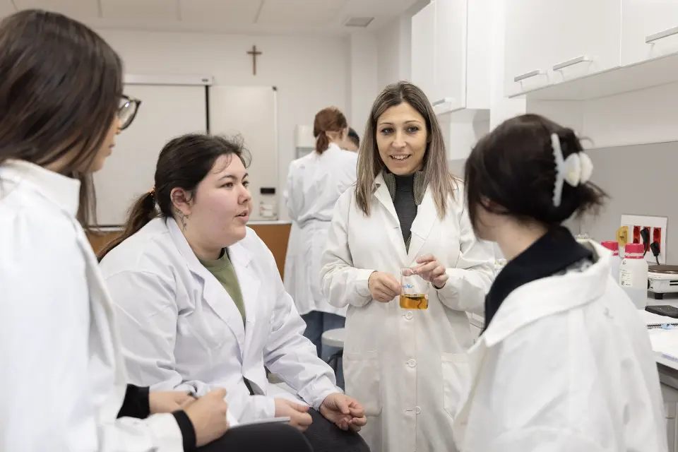 Dr. Hillary with nursing students Three students and a professor have a discussion while sitting around an outdoor table with a laptop.