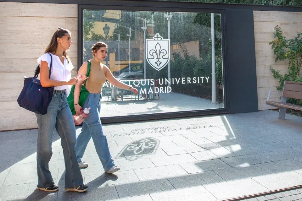 Students leaving SIH building. Two students walking outside a building.