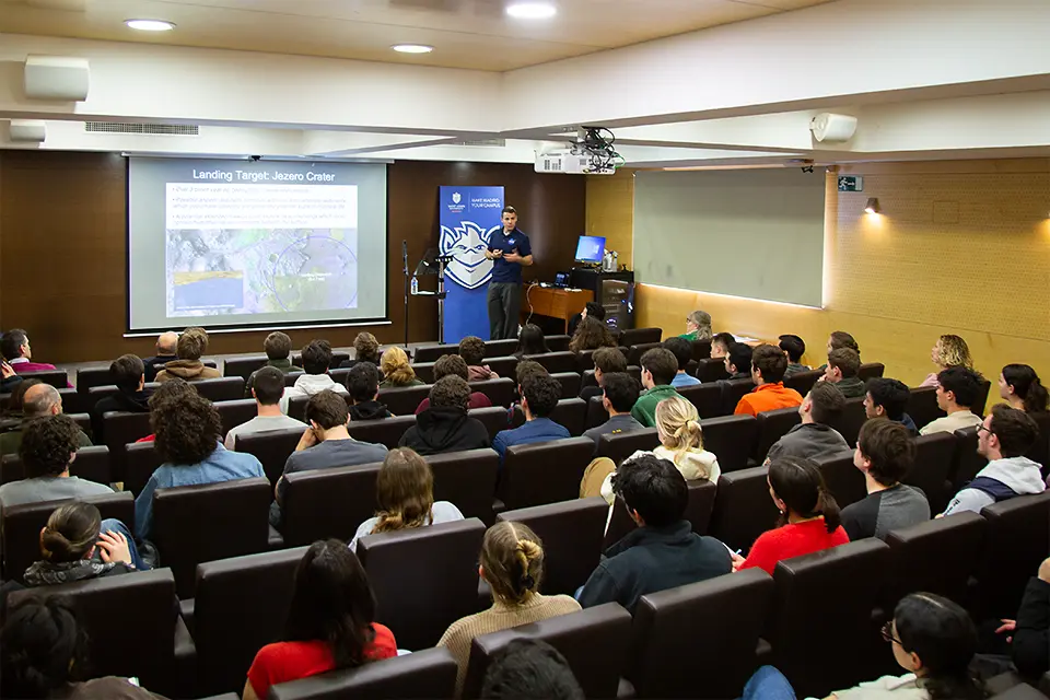 Fernando Abilleira presented "Perseverance and Mars Exploration" on campus to faculty, staff and students in the San Ignacio Hall Auditorium. A man on stage speaks to audience in auditorium with a science presentation projected on the screen.