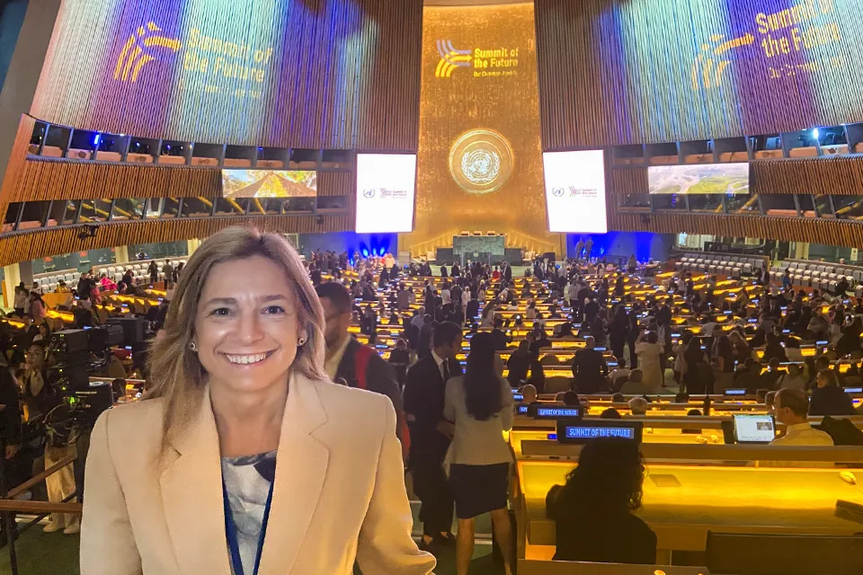 Laura Muro Represents SLU-Madrid at UN Woman smiles at camera in front of meeting space at the UN's headquarters.