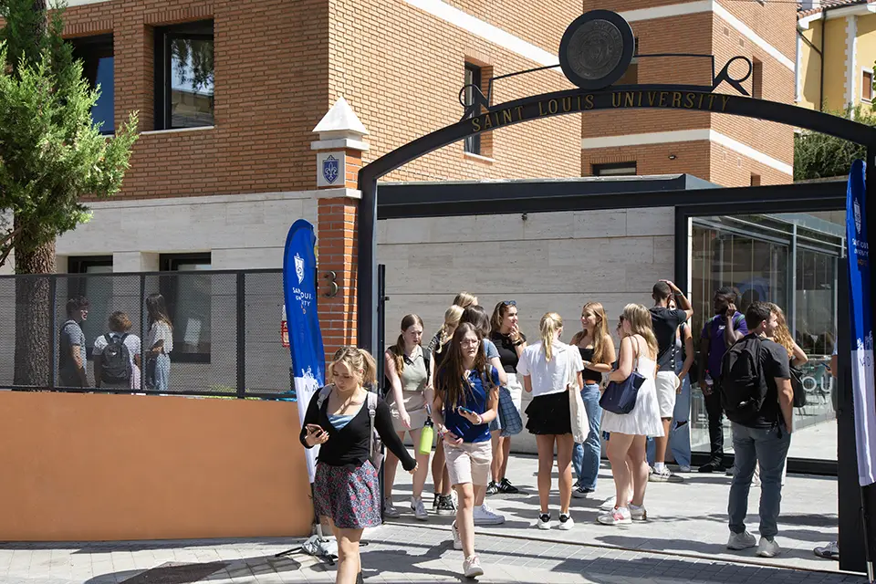 SLU-Madrid will welcome transfer, visiting and permanent degree-seeking students on Jan. 9 at campus orientation. Students walk through and stand and talk in an outdoor area of the SLU Madrid campus.